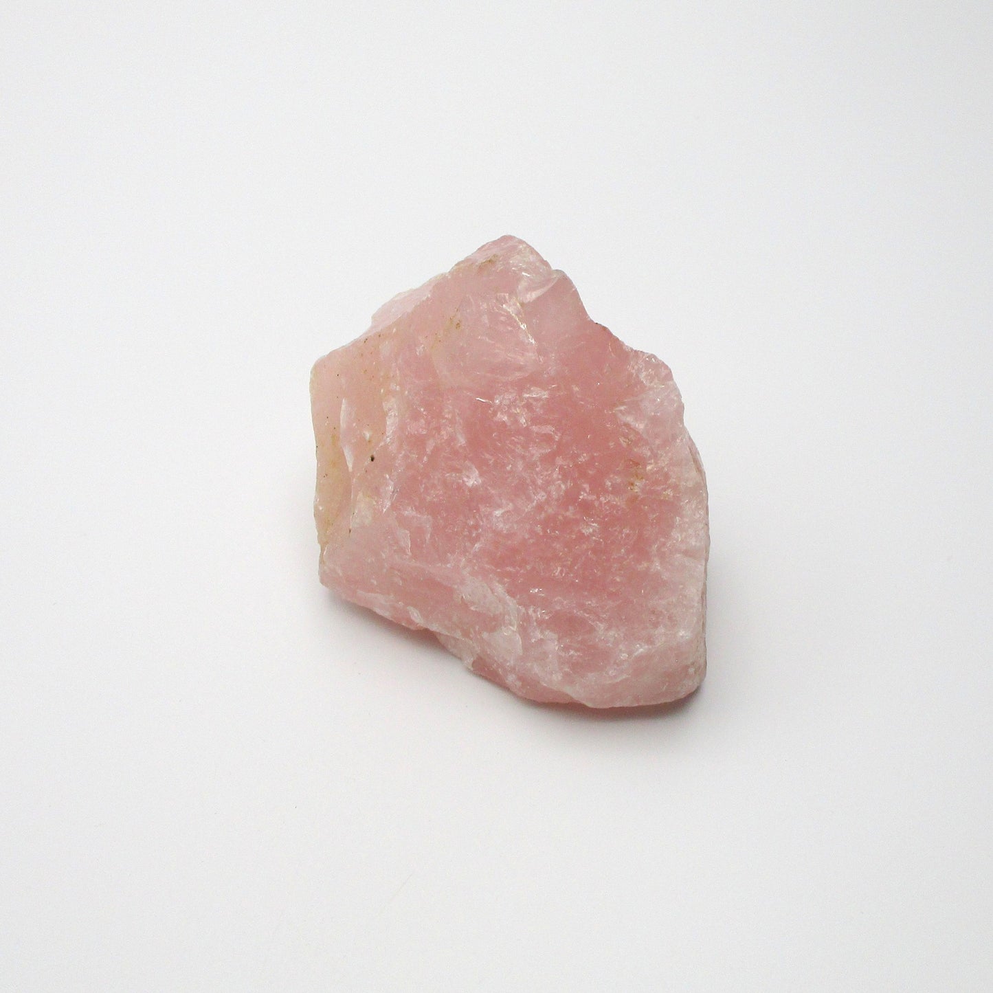 A pink rose quartz crystal on a white background