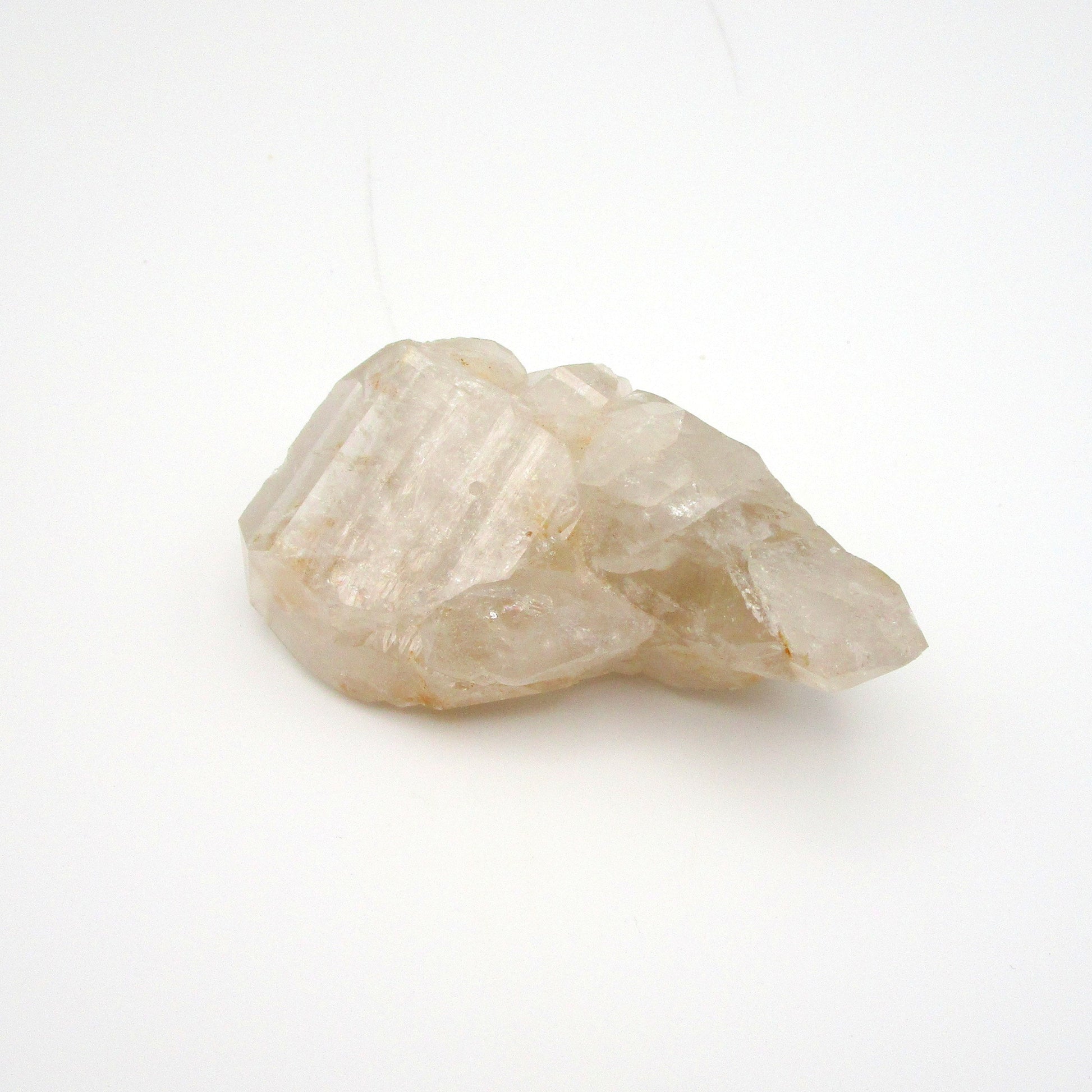 A rough, uncut Russian Quartz crystal point against a white background.