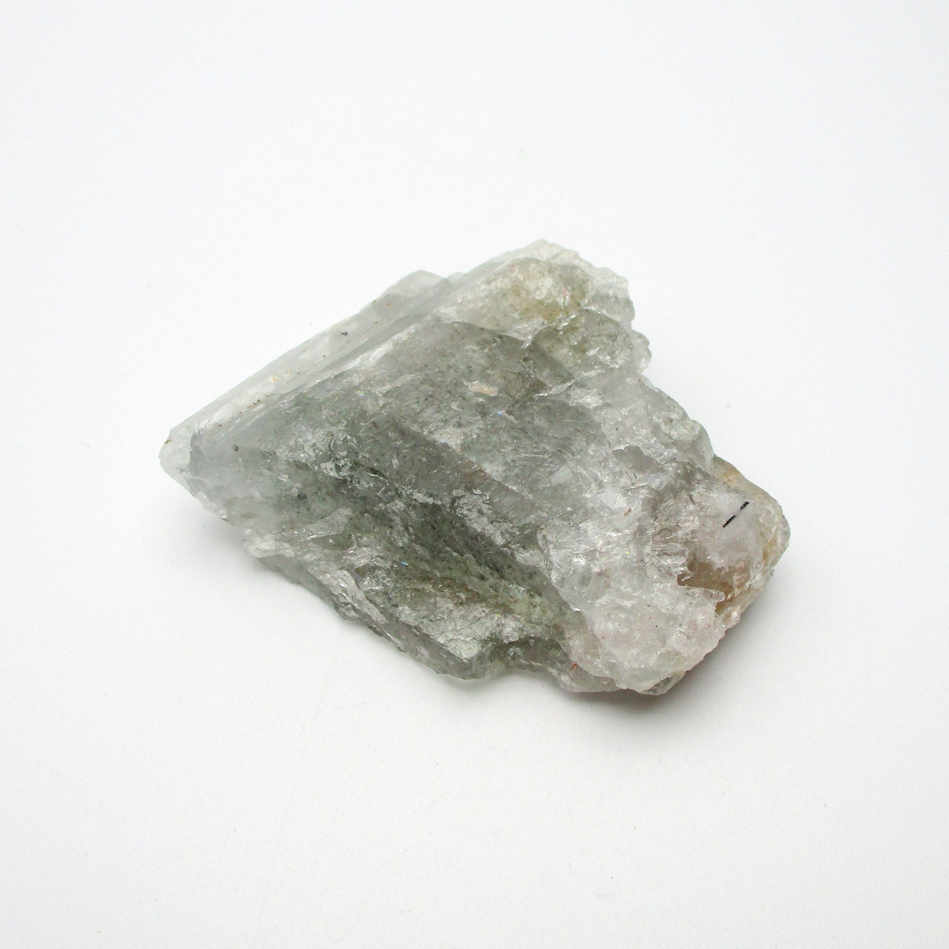 A rough Aquamarine crystal with a translucent greenish appearance, displayed on a white background.