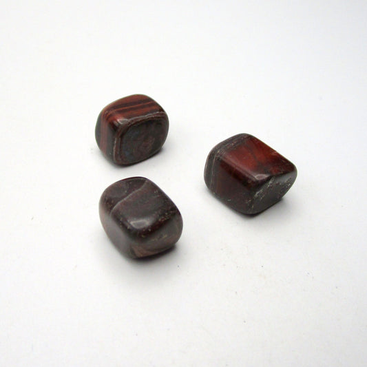 Set of three tumbled red tigers eye on white background