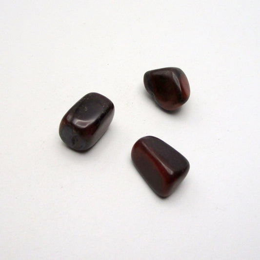 Set of three tumbled red tigers eye on white background