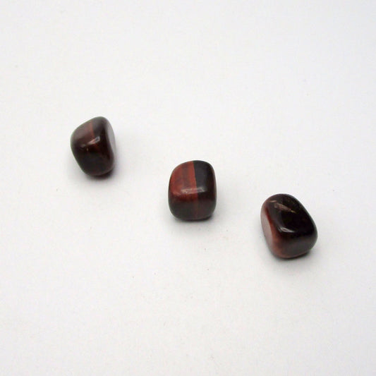 Set of three tumbled red tigers eye on white background