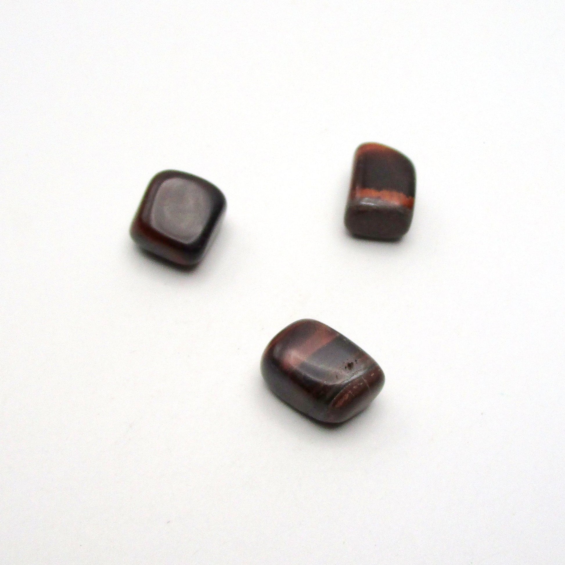 Set of three tumbled red tigers eye on white background