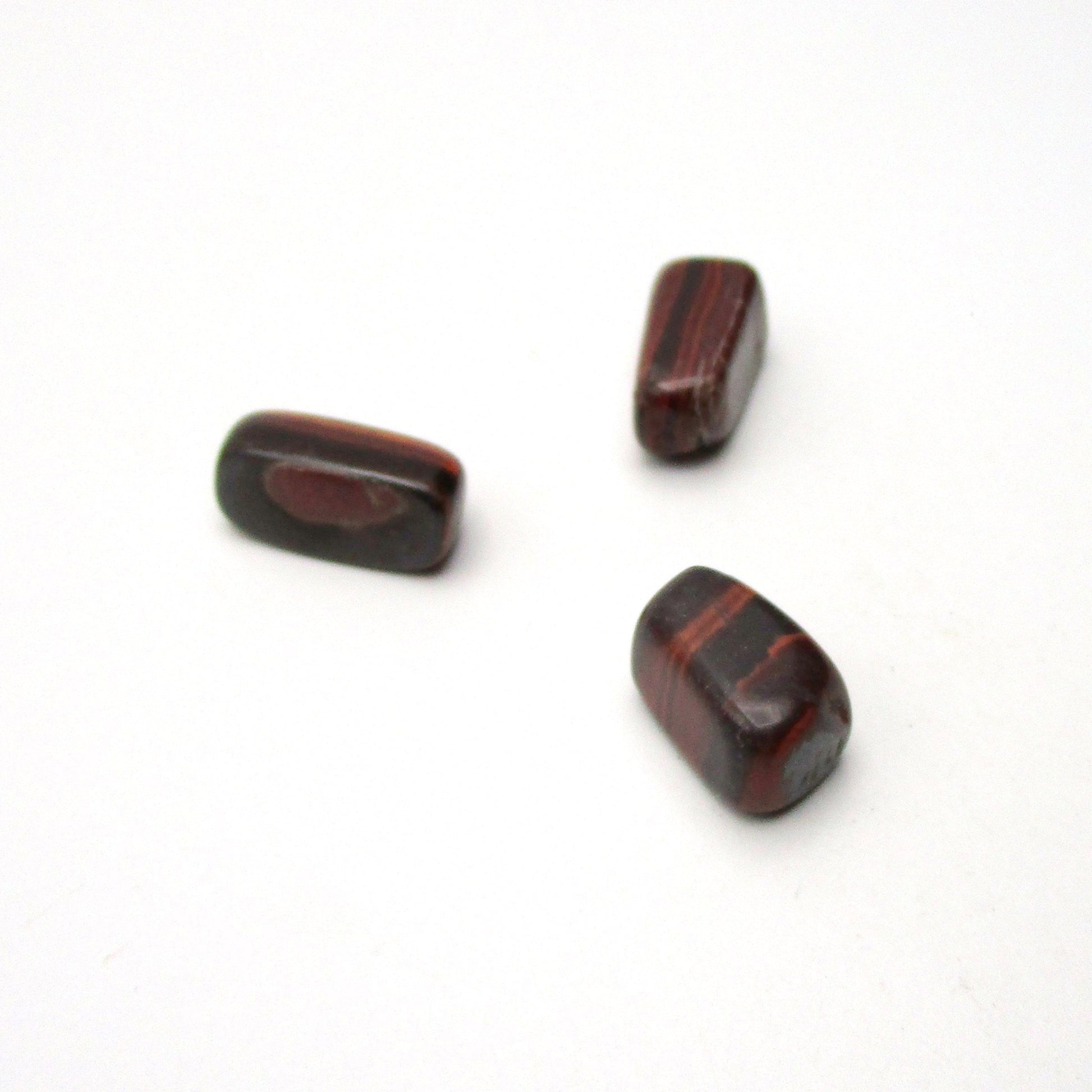 Set of three tumbled red tigers eye on white background