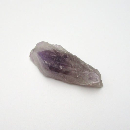 A raw Brazilian Amethyst crystal point with a range of purple colors.