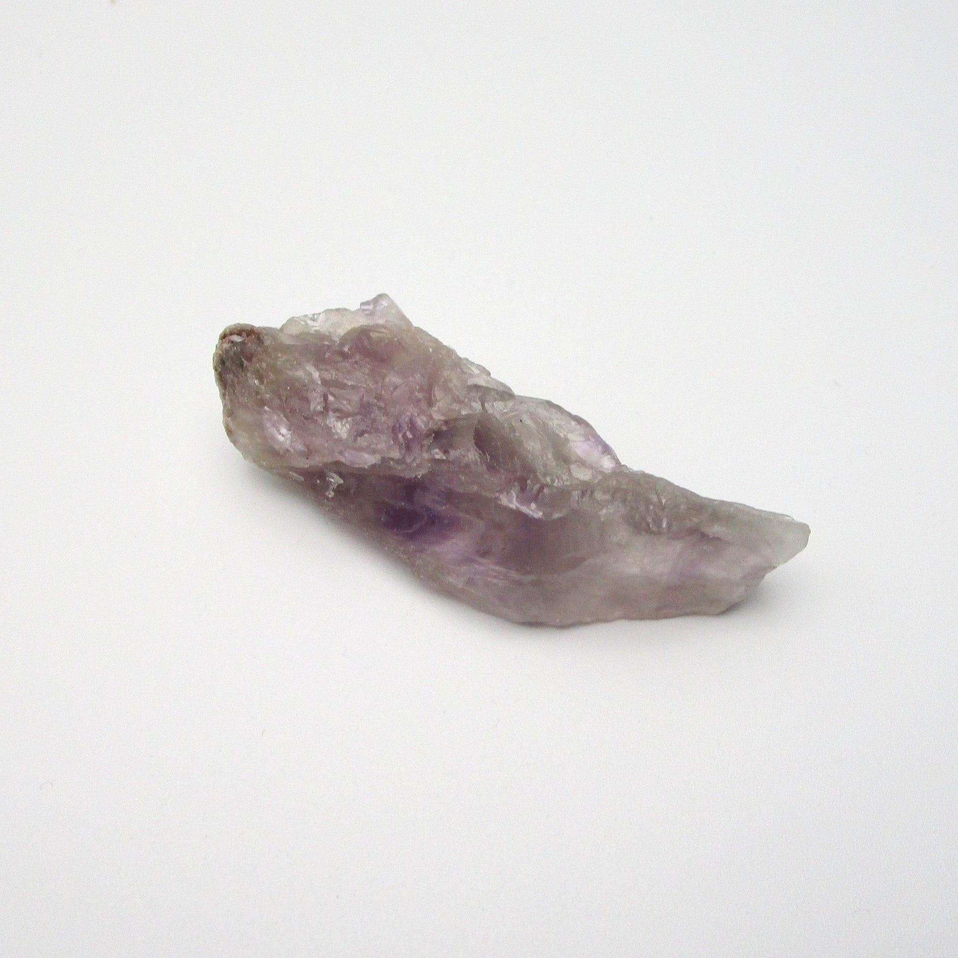 A raw Brazilian Amethyst crystal point with a range of purple colors.