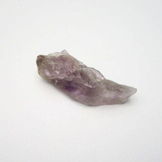 A raw Brazilian Amethyst crystal point with a range of purple colors.