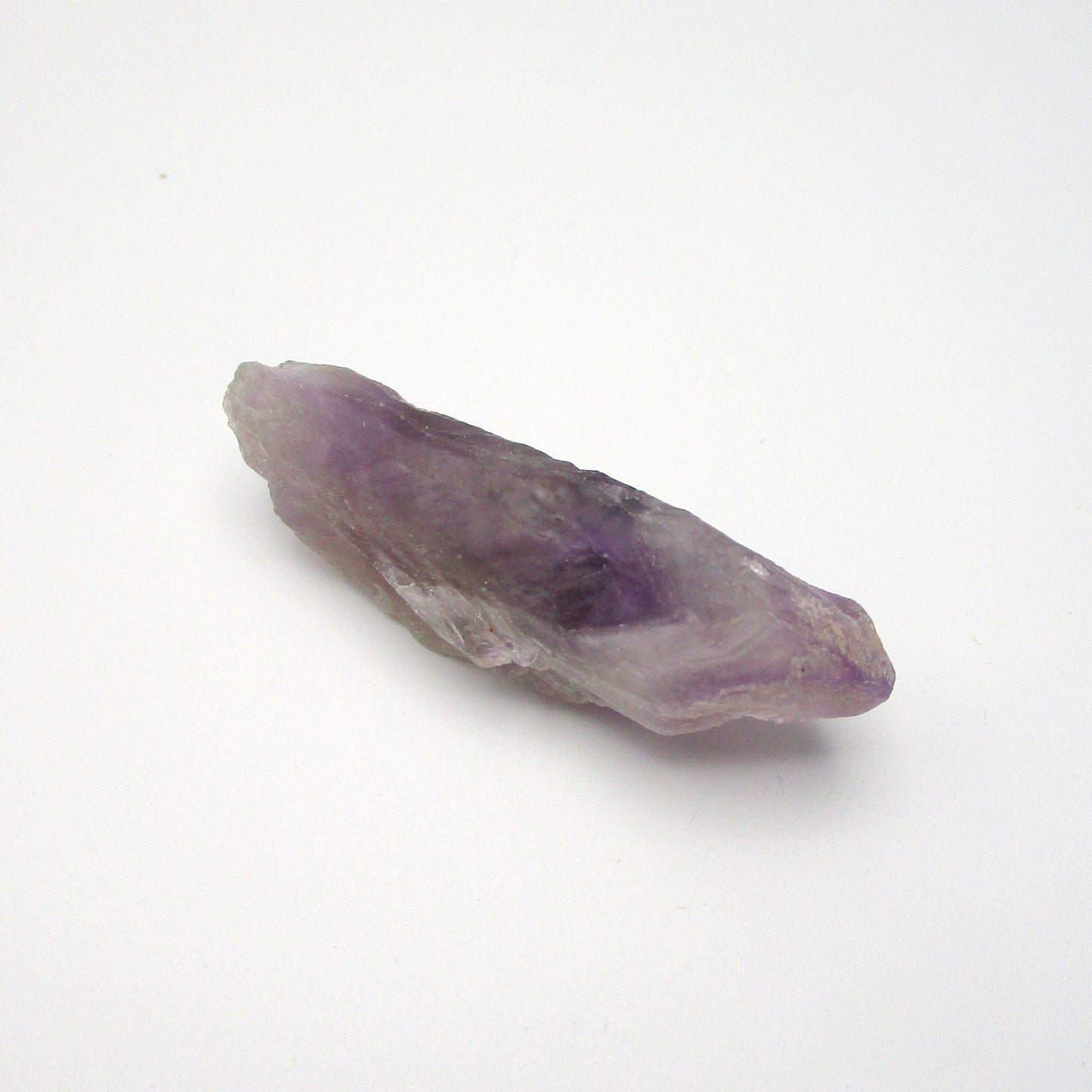 A Brazilian Amethyst Point crystal with a range of purple colors, approximately 2.25 inches long, displayed on a white background.
