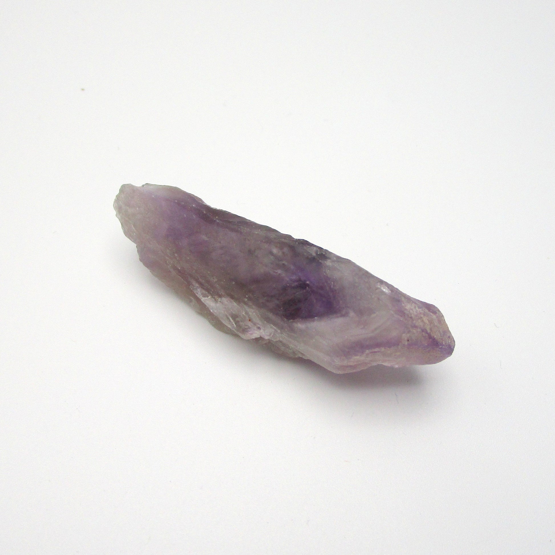 A Brazilian Amethyst Point crystal with a range of purple colors, approximately 2.25 inches long, displayed on a white background.
