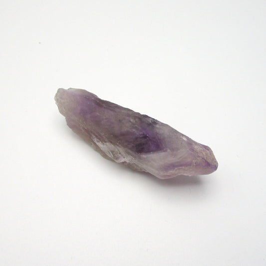 A Brazilian Amethyst Point crystal with a range of purple colors, approximately 2.25 inches long, displayed on a white background.