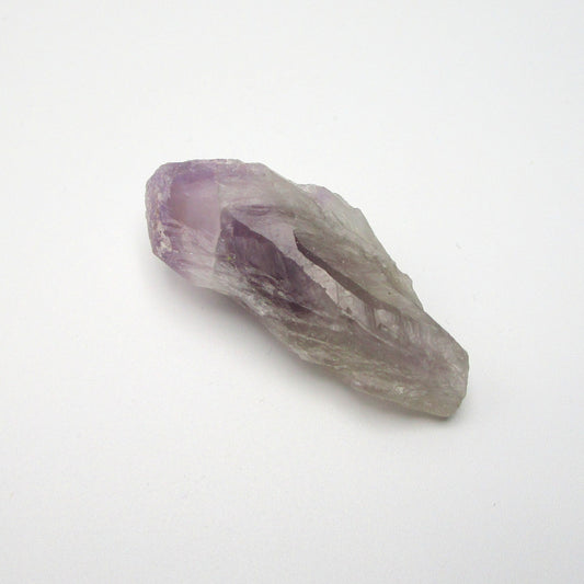 A Brazilian Amethyst Point crystal with a range of purple colors against a white background.