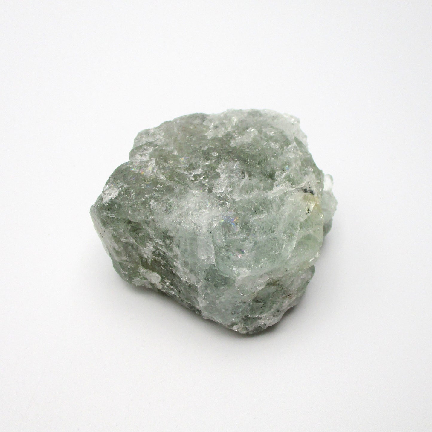 A rough, raw Aquamarine crystal with a greenish tint on a white background.