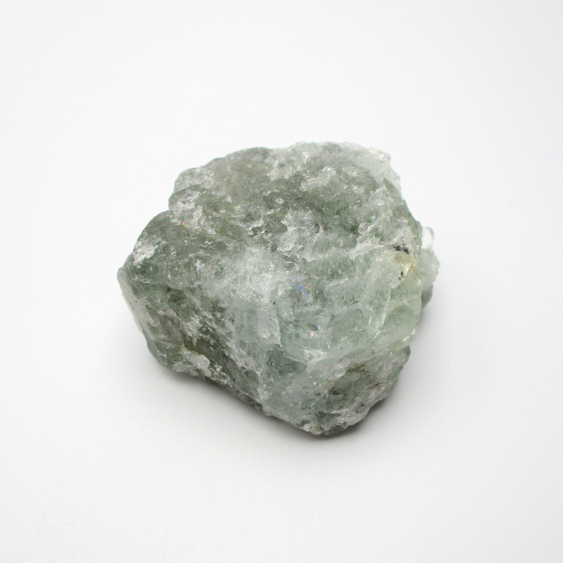 A rough, raw Aquamarine crystal with a greenish tint on a white background.