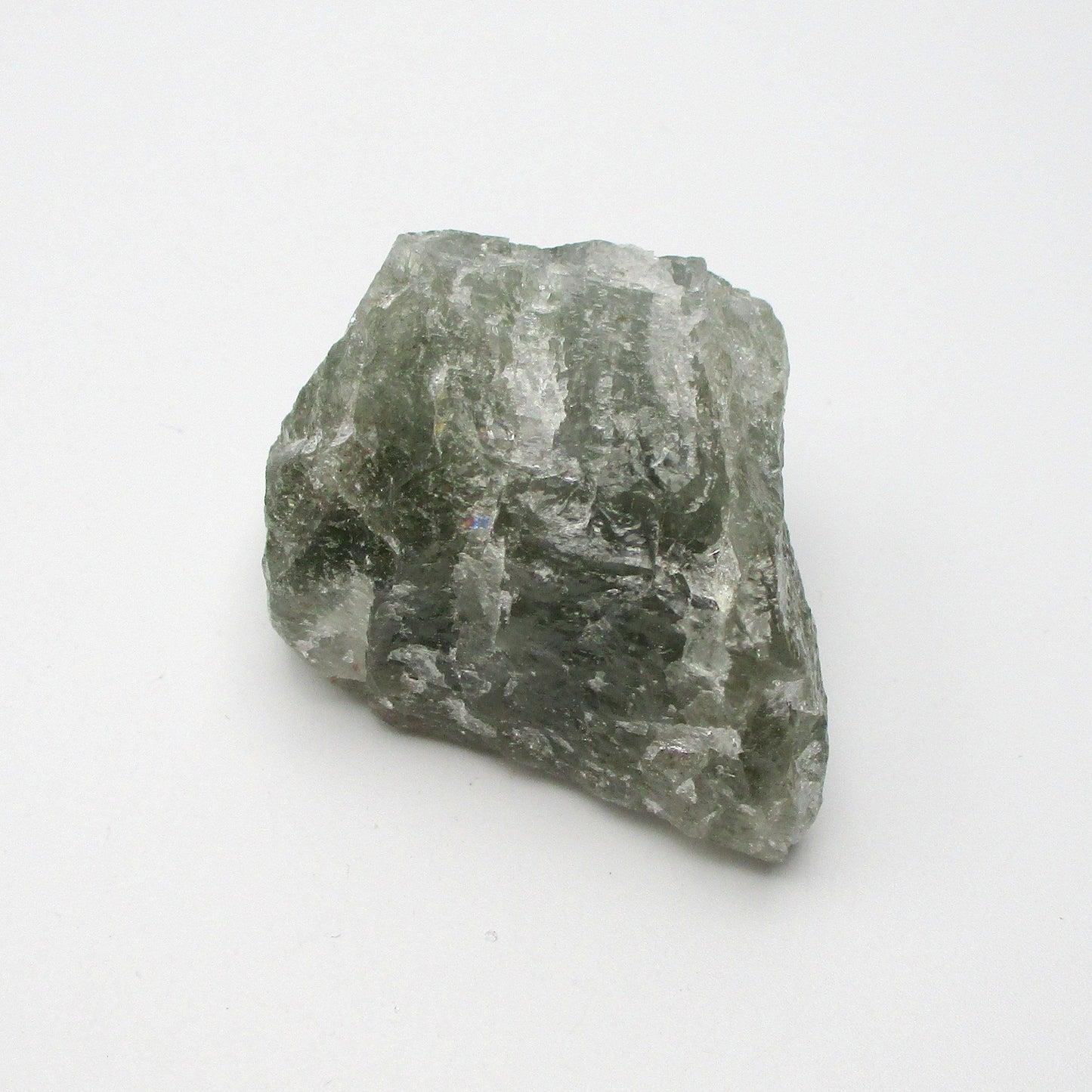 A rough Aquamarine crystal with a greenish tint against a white background.