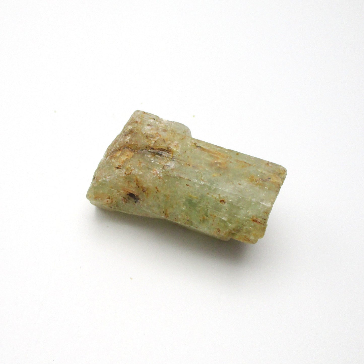 A rough Aquamarine crystal against a white background