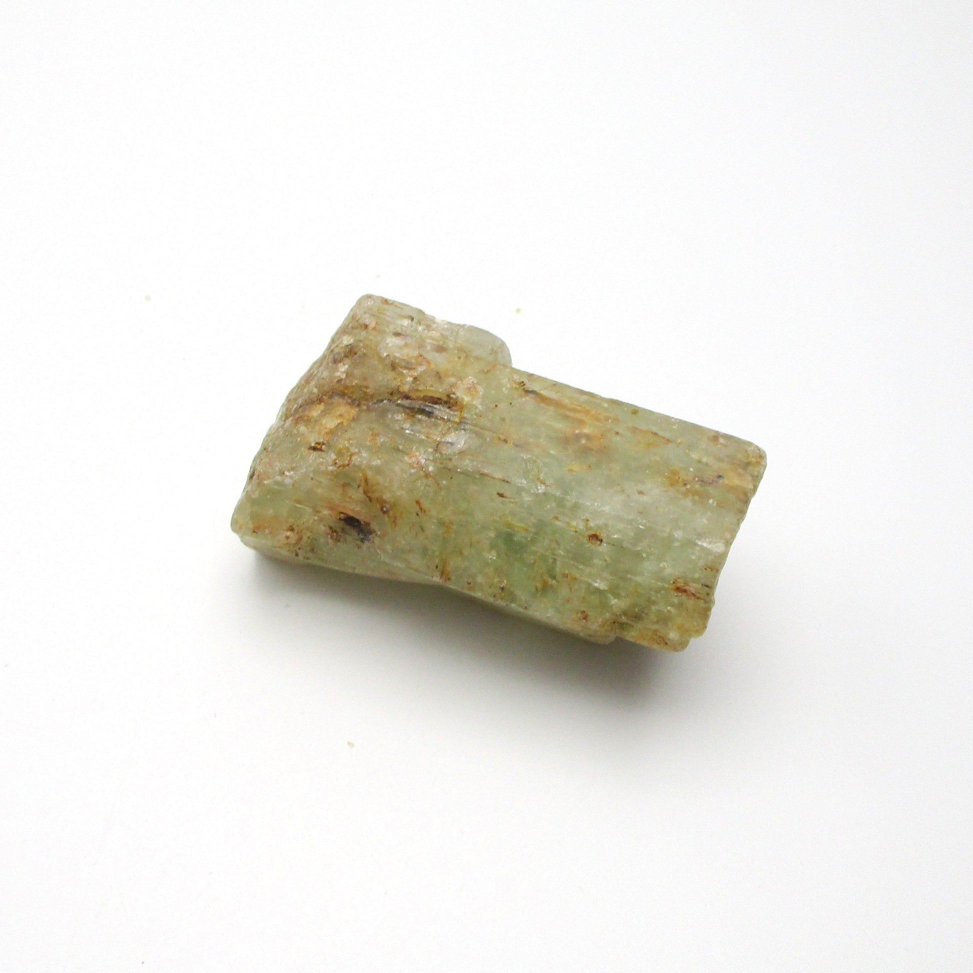 A rough Aquamarine crystal against a white background