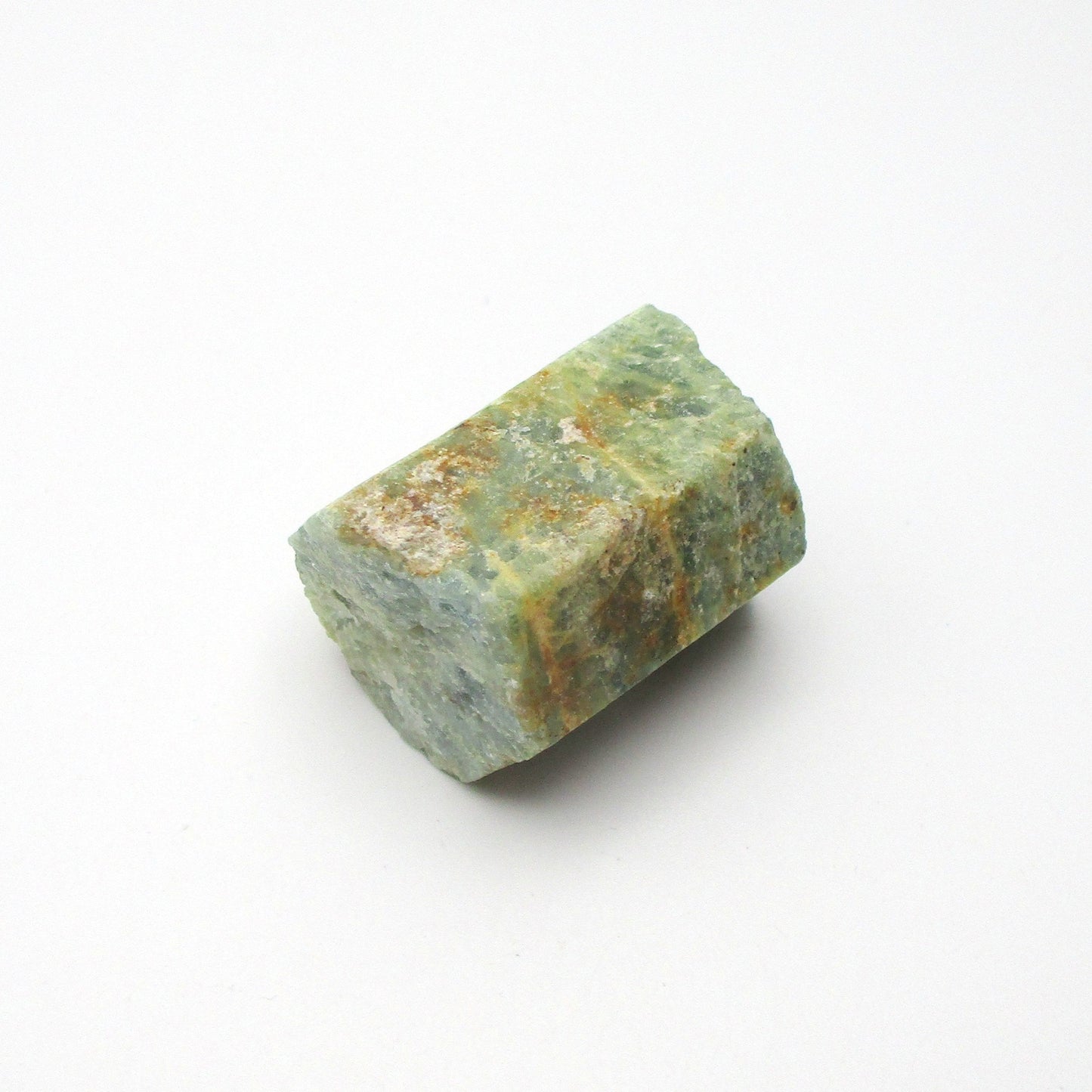 A rough Aquamarine crystal with a greenish hue on a white background.