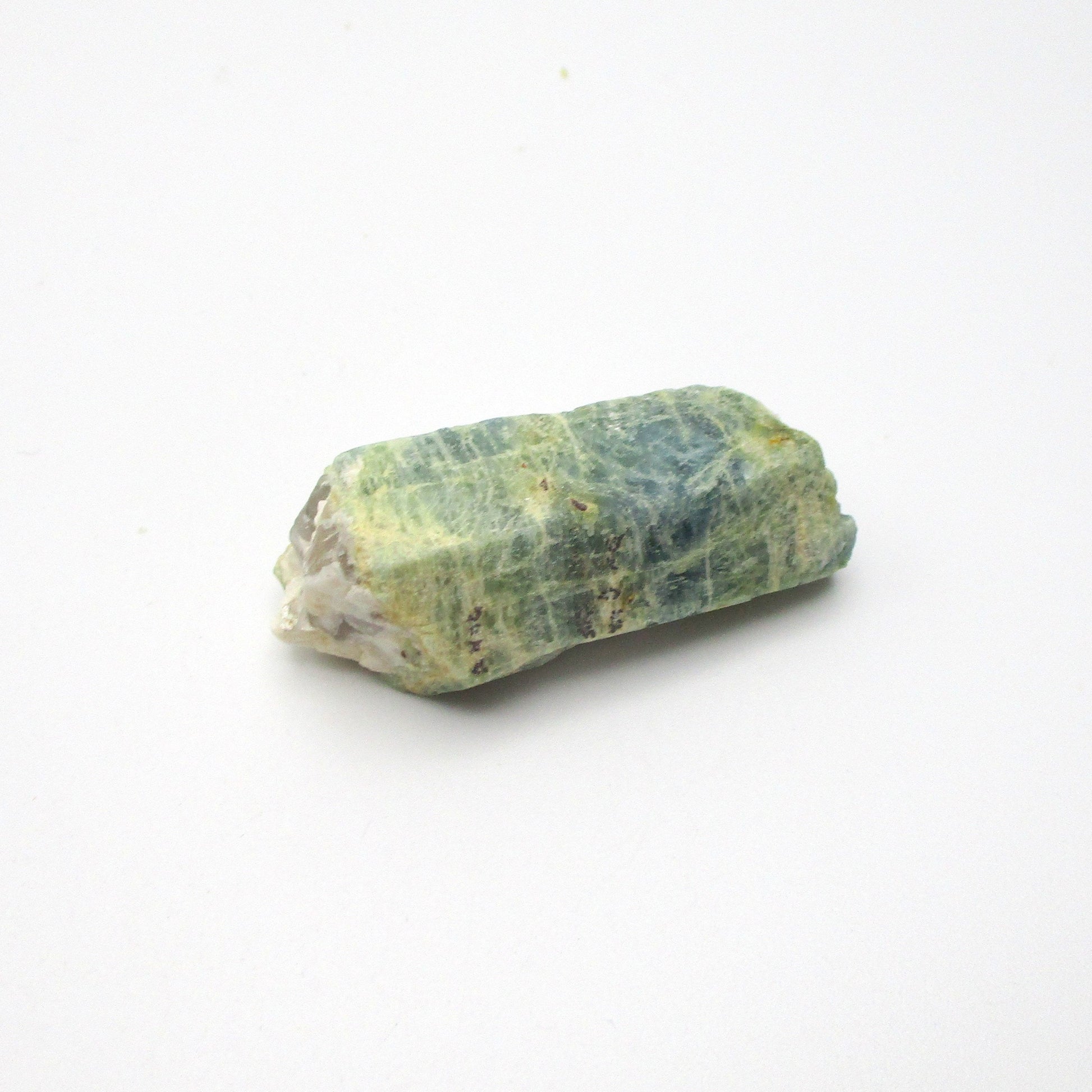 A rough Aquamarine crystal against a white background