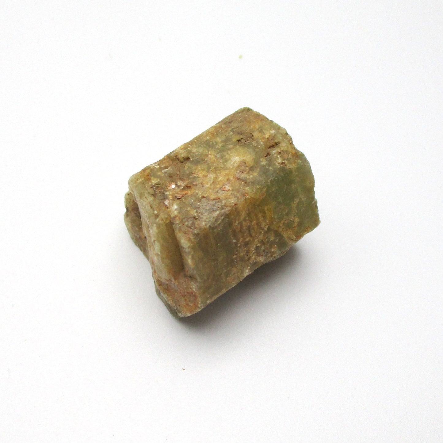 A rough Aquamarine crystal with a greenish tint on a white background.