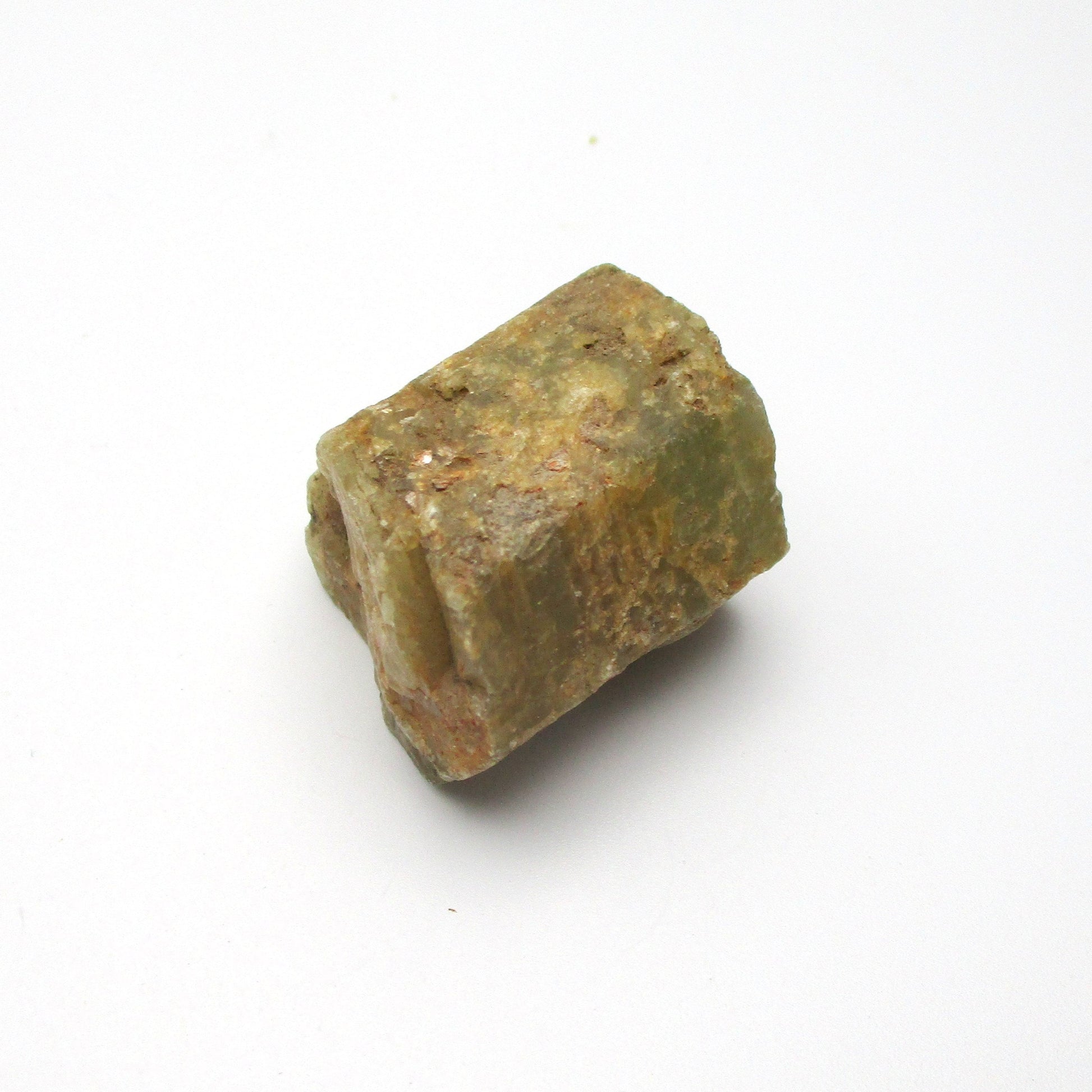 A rough Aquamarine crystal with a greenish tint on a white background.
