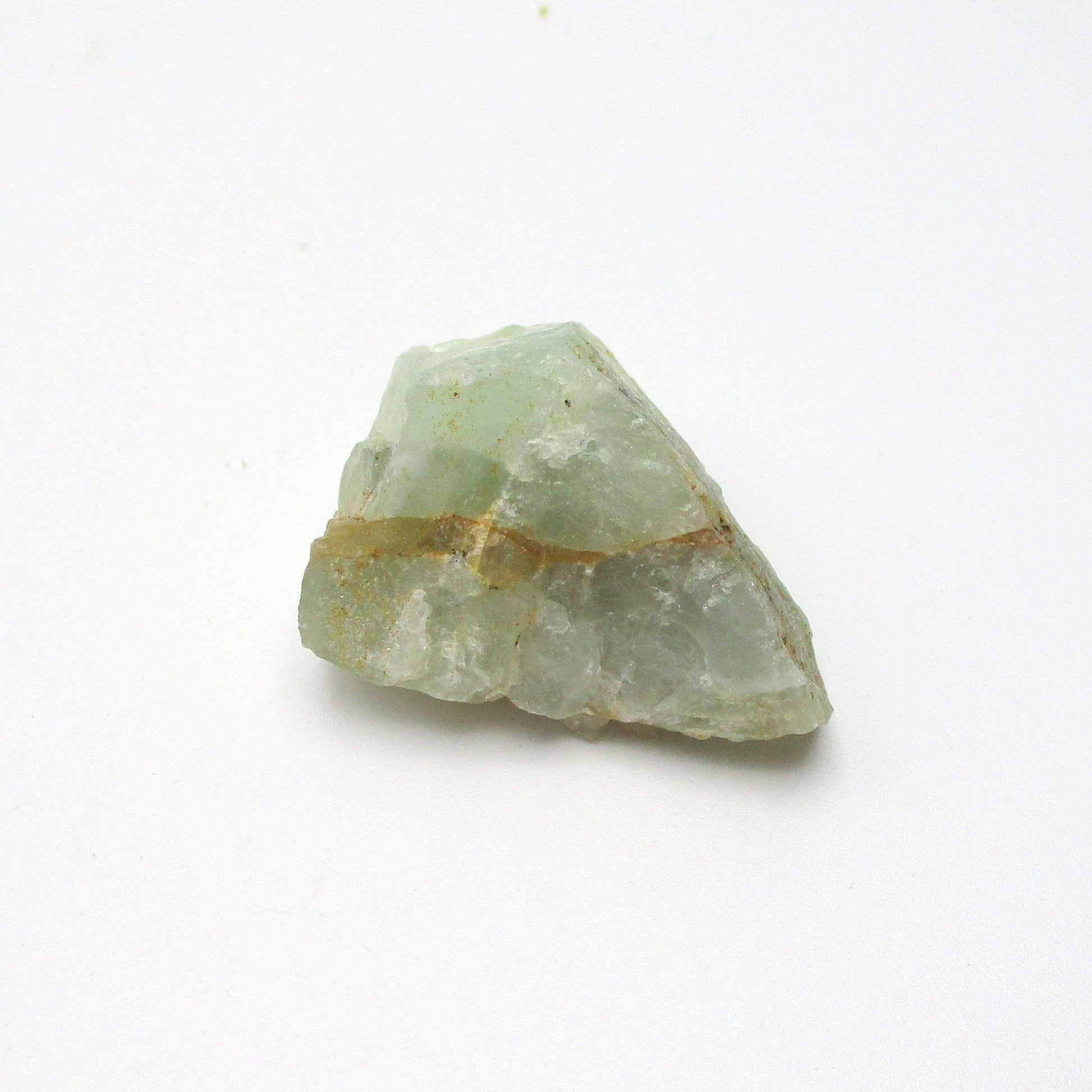 A rough-cut Aquamarine gemstone with a pale blue color and inclusion lines, displayed on a white background.