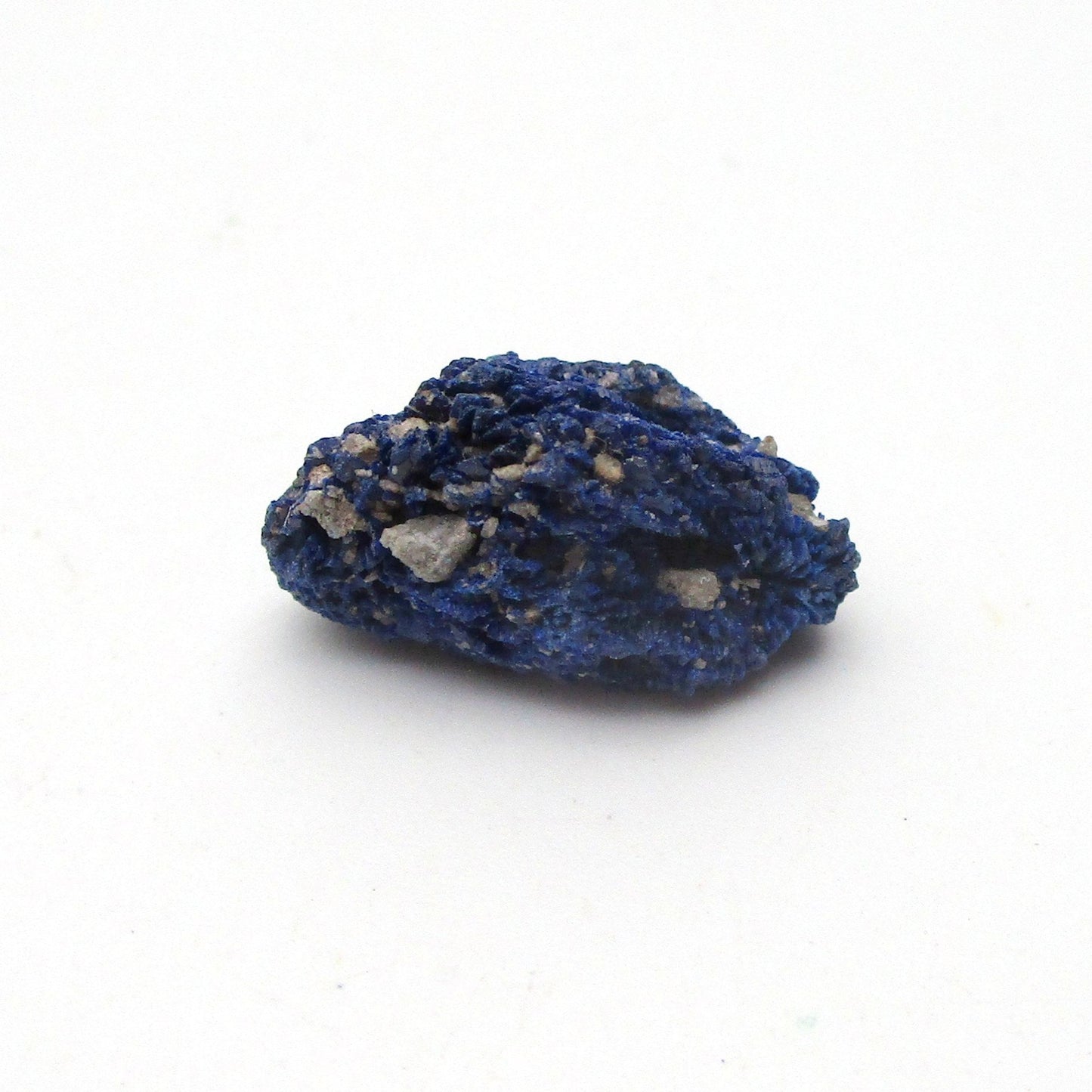 small blue azurite crystal on a white background