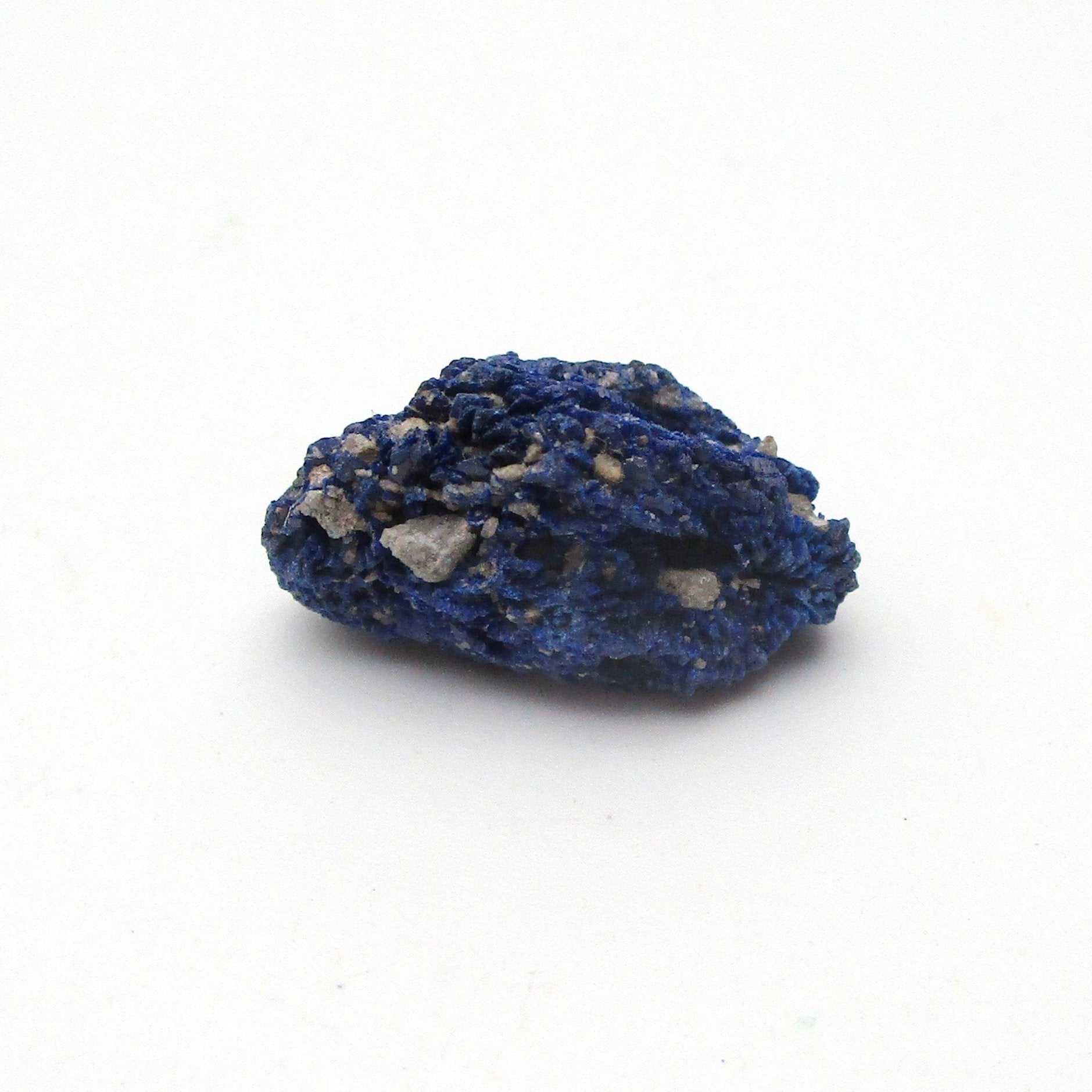 small blue azurite crystal on a white background