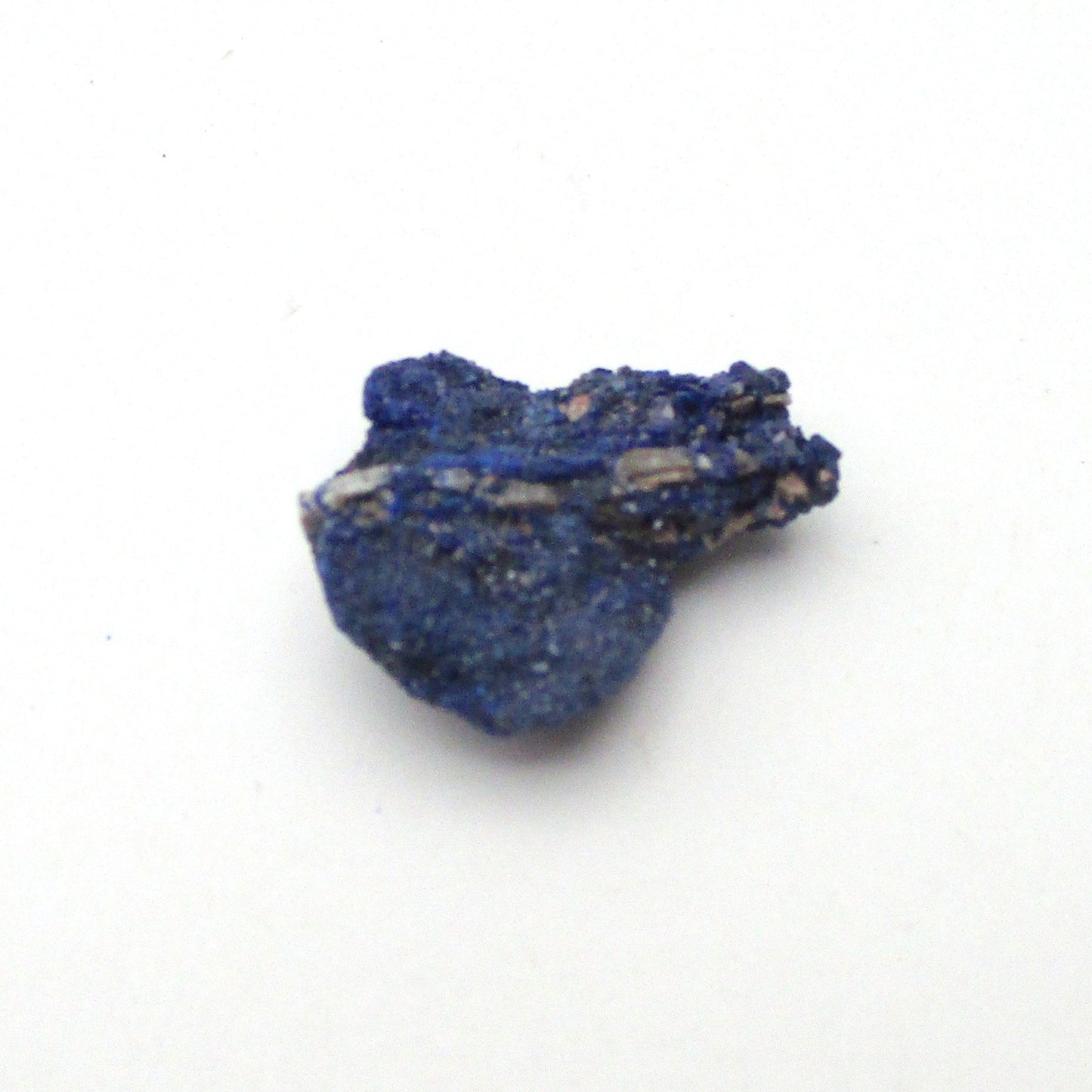 small blue azurite crystal on a white background