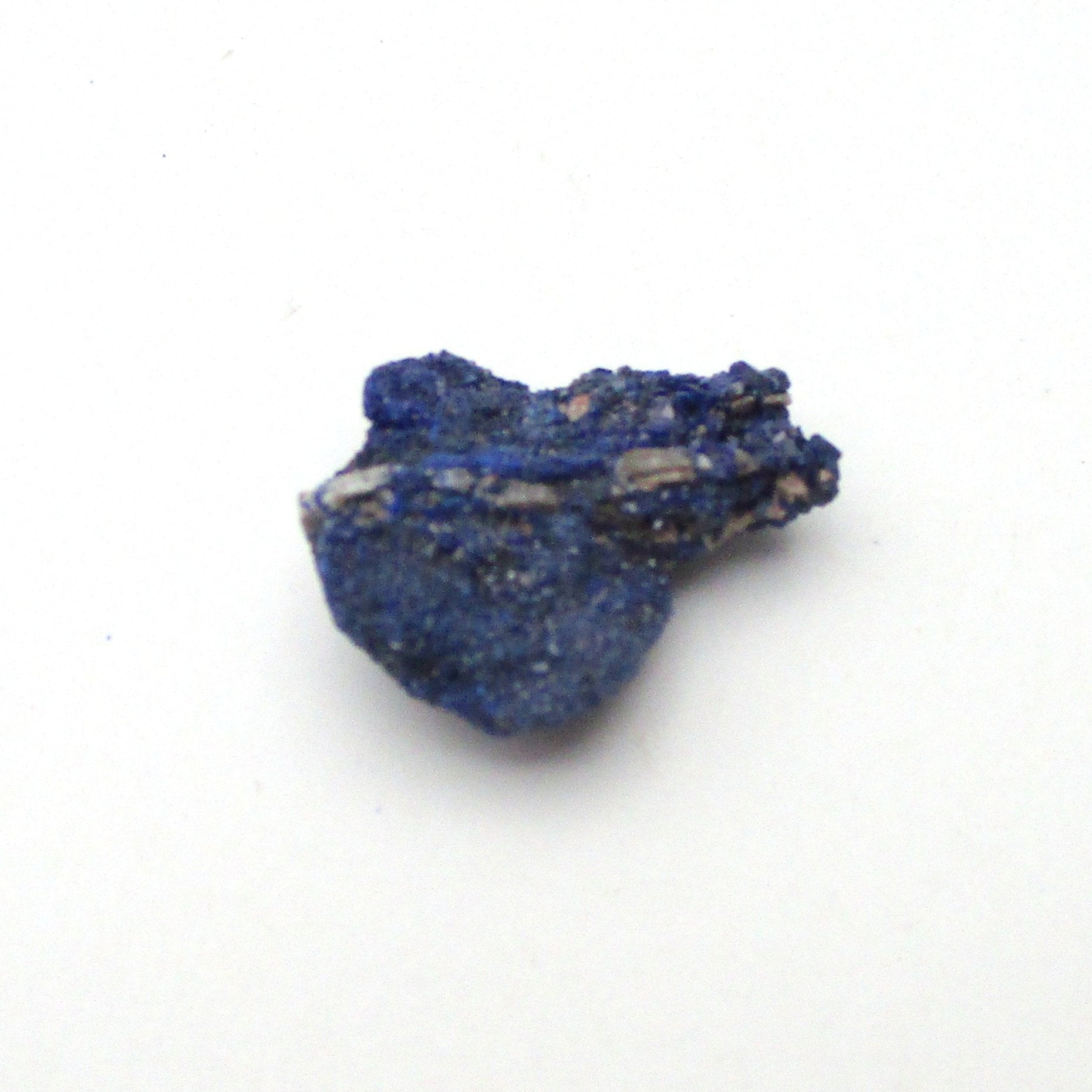 small blue azurite crystal on a white background
