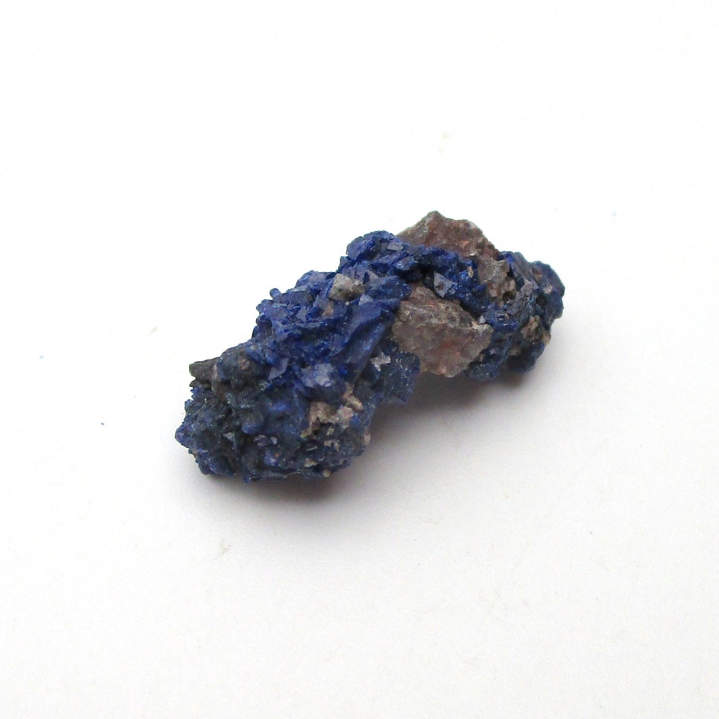 small blue azurite crystal on a white background