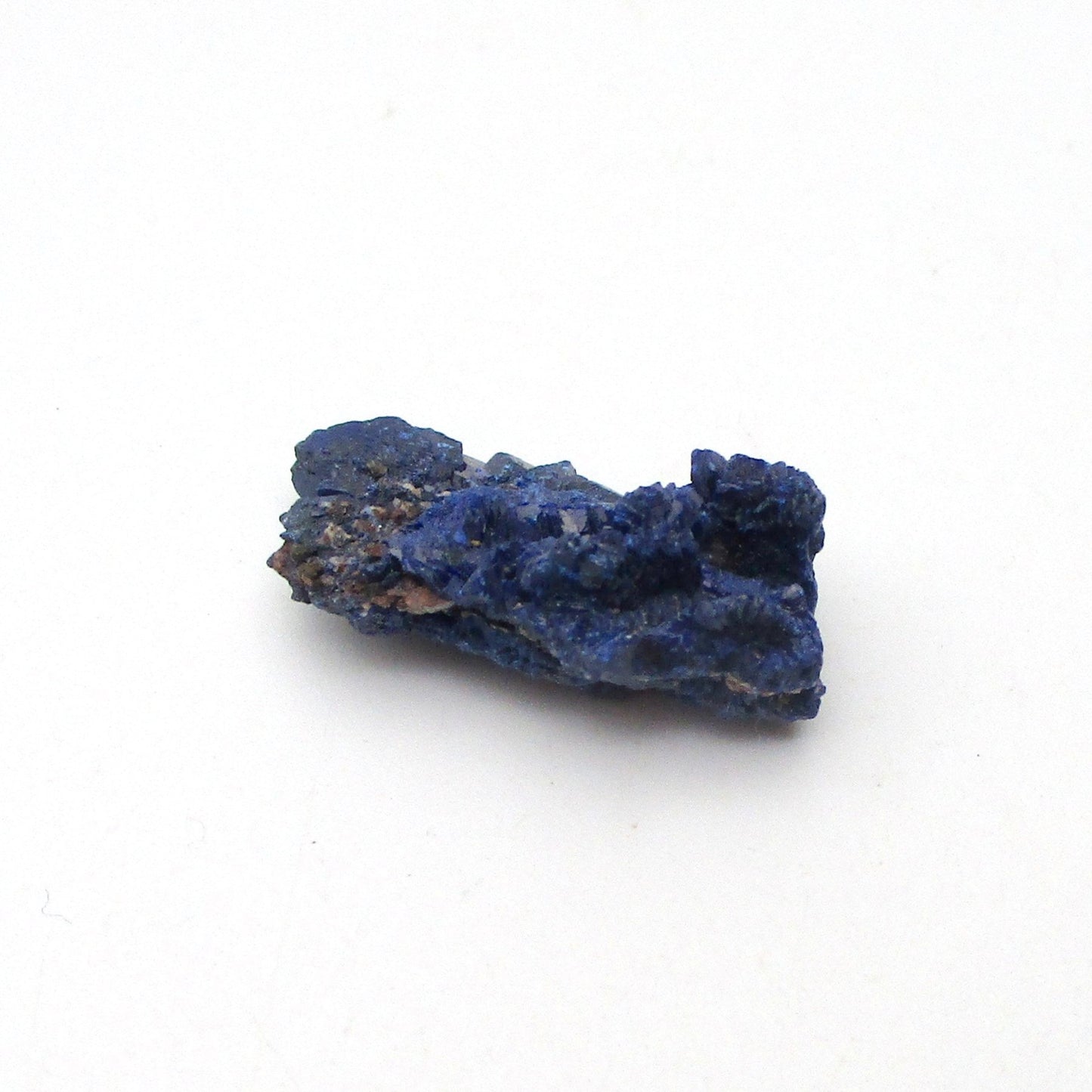 small blue azurite crystal on a white background