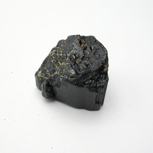 A rough, black crystal piece of Black Tourmaline against a white background.