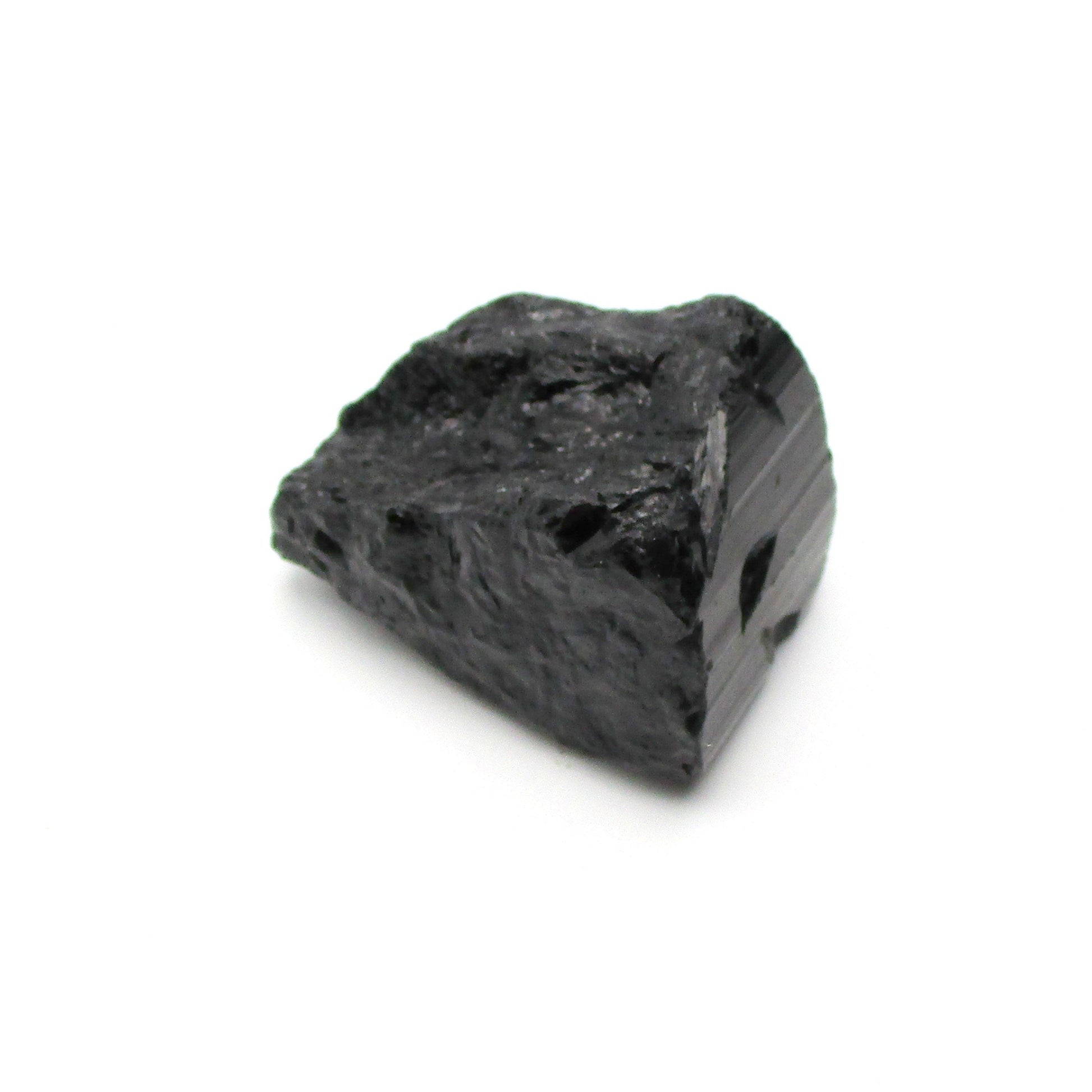 A rough, black tourmaline crystal with a metallic sheen, approximately 1 inch in size, displayed on a white background.