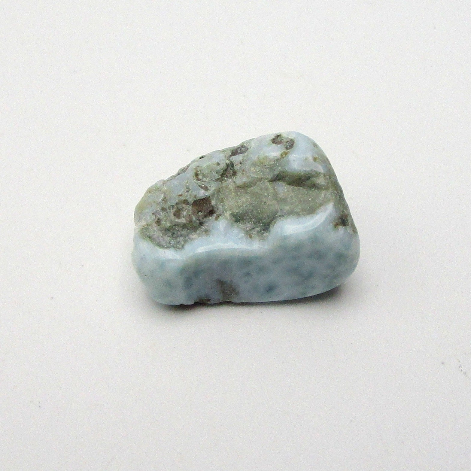 A polished, smoothed Larimar crystal with a blue and white color scheme, approximately 0.5 inches in size, placed on a white background.