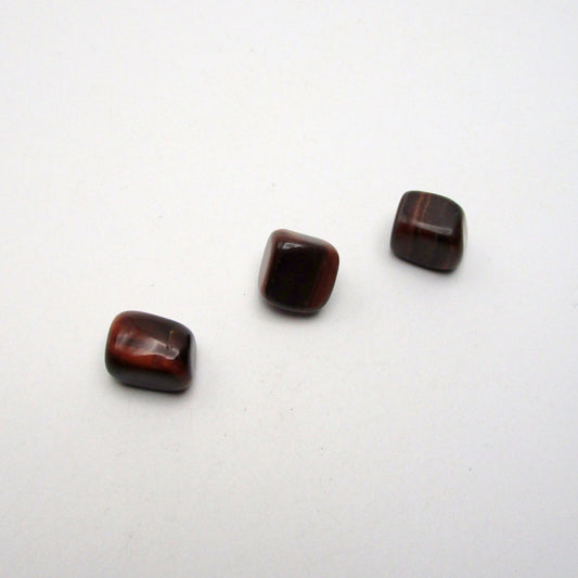 Set of three tumbled red tigers eye on white background
