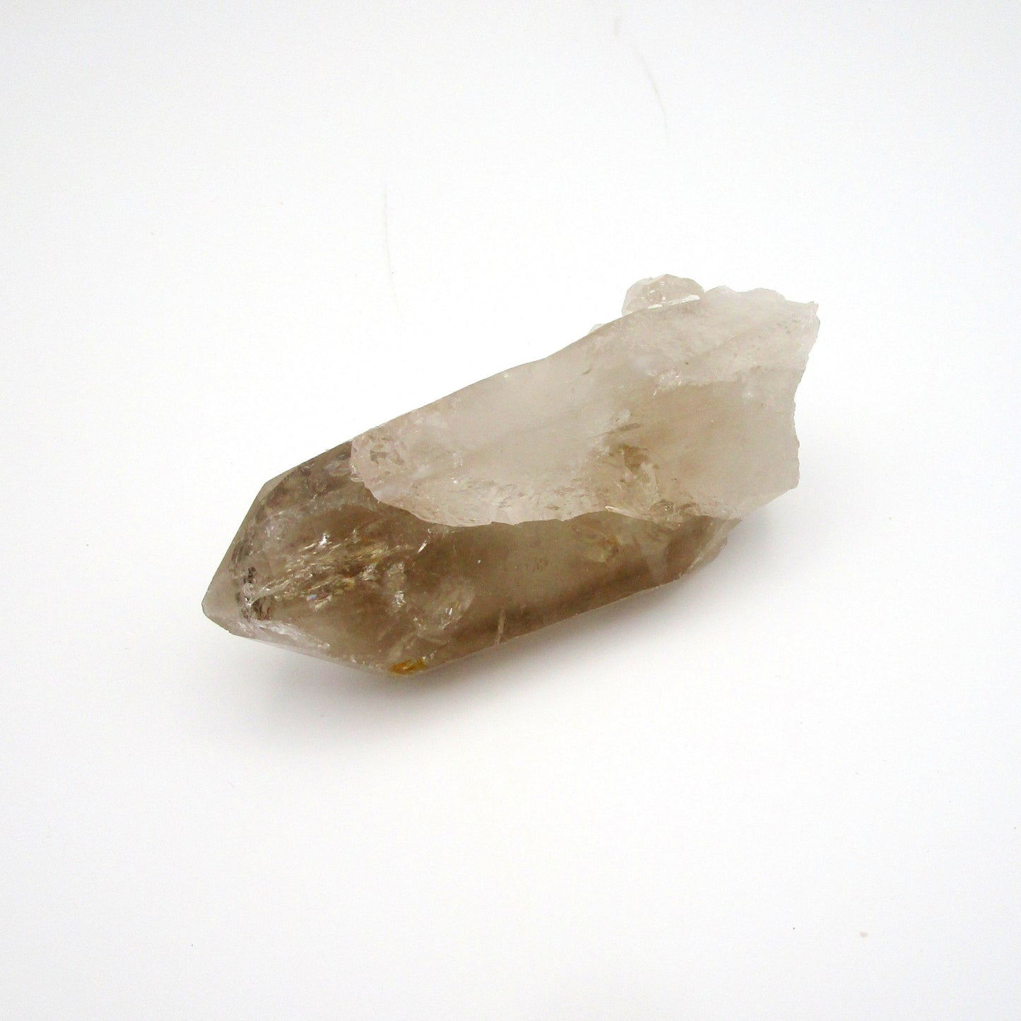 A rough, uncut Russian Quartz crystal point against a white background.